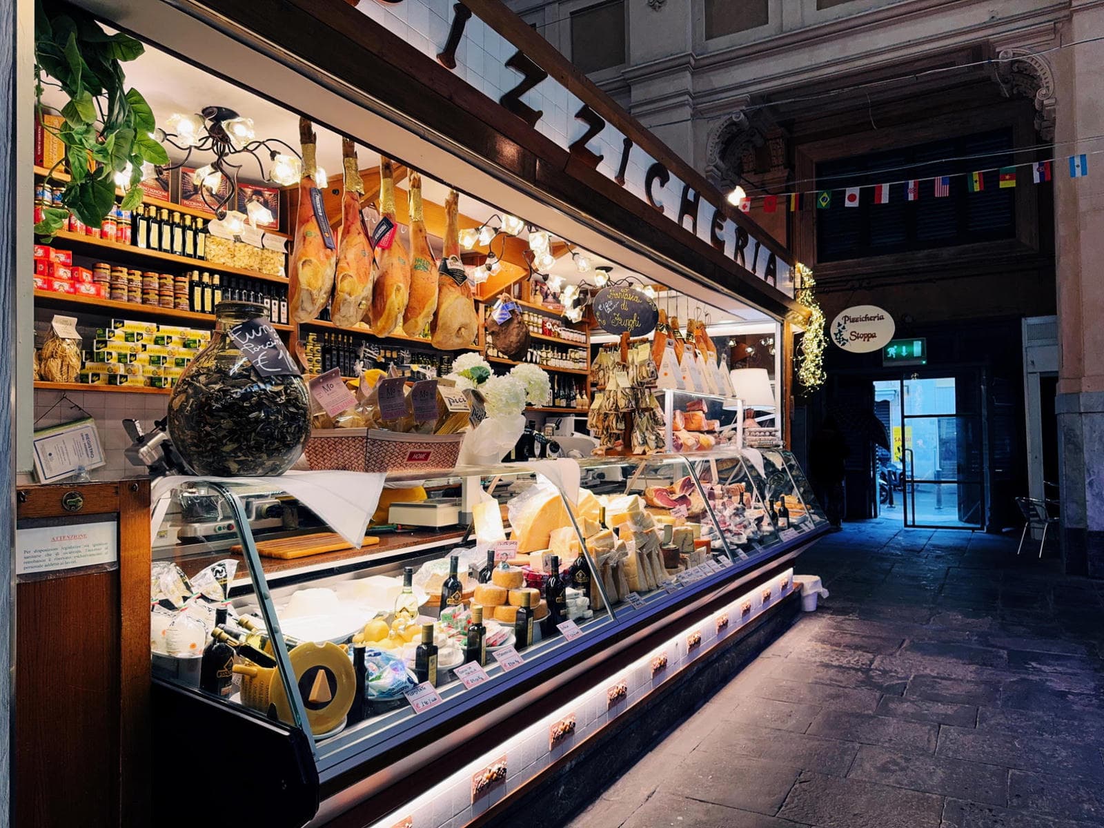 Market stall hanging with Cured hams, salami and excellent Pecorino cheeses livrono-pizzicheria